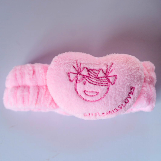 Pink eye mask with a cartoon design on a light gray background