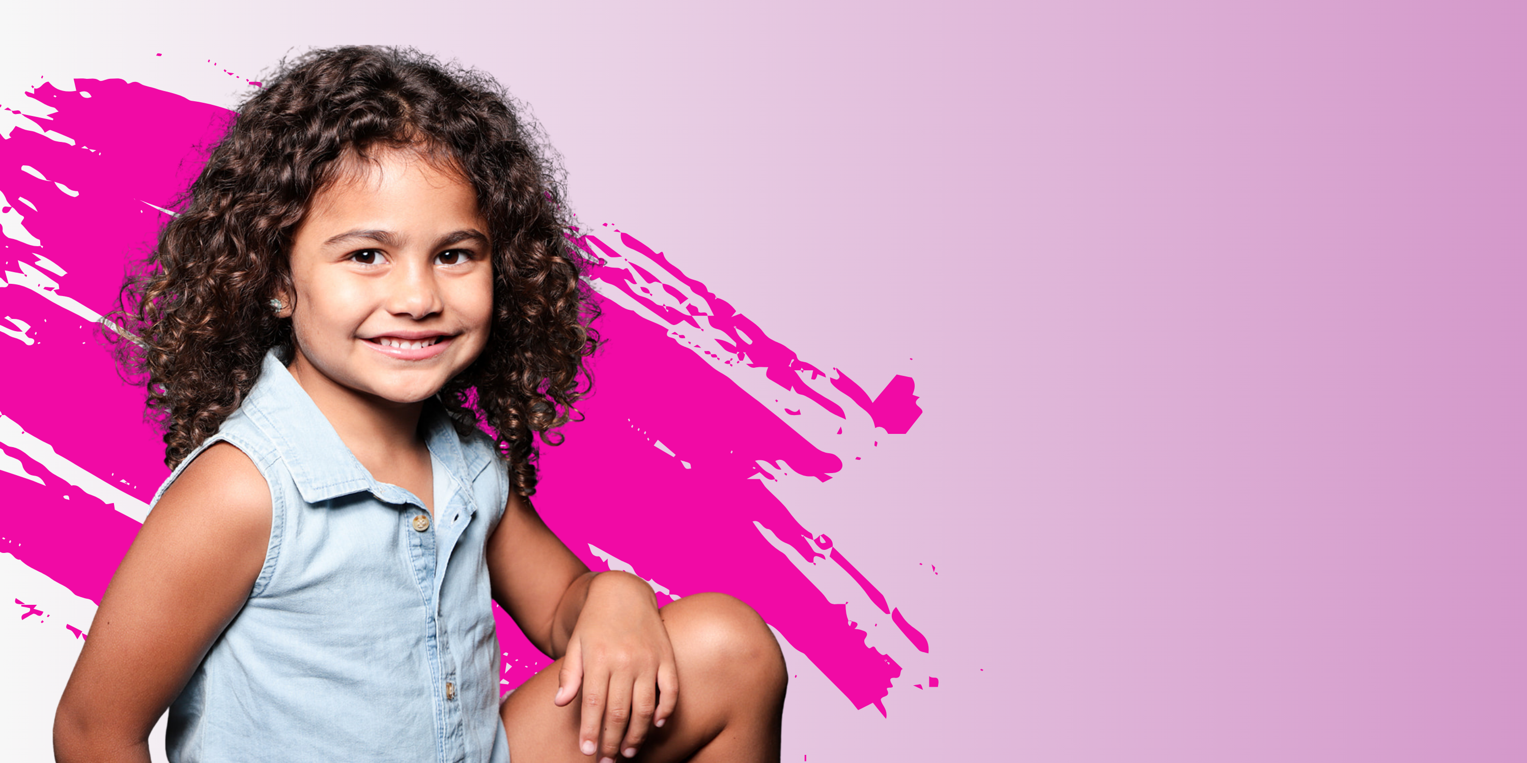Young girl with curly hair sitting against a pink and purple abstract background